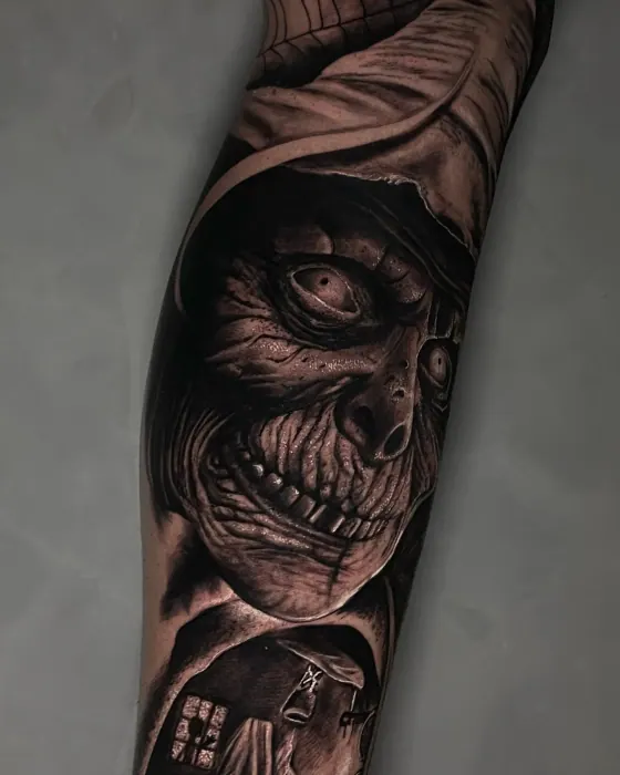 Detalhe do rosto de uma bruxa tatuada na perna