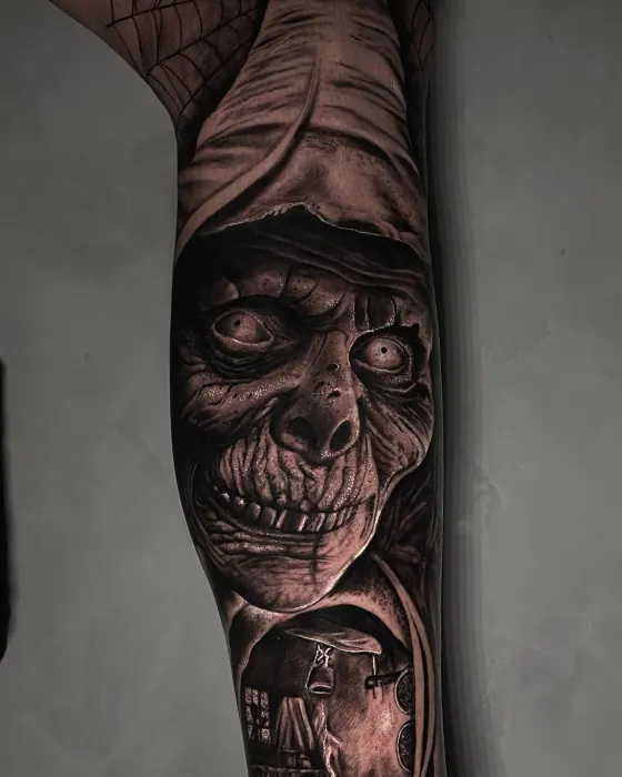 Detalhe do rosto de uma bruxa tatuada em preto e cinza